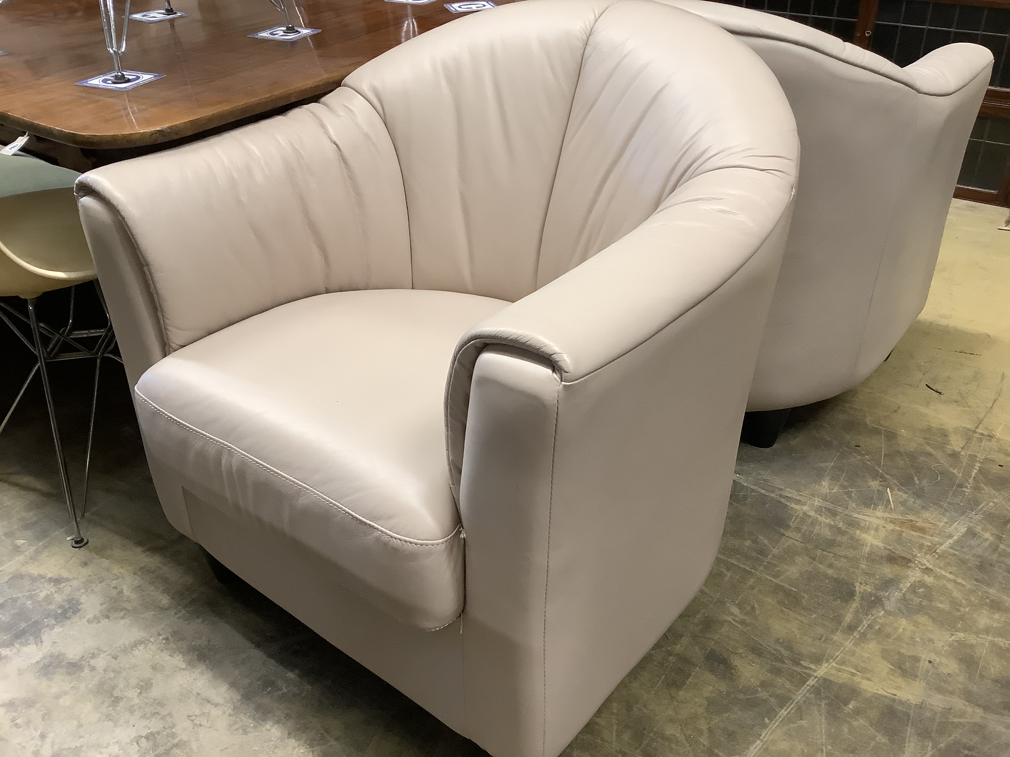 A pair of contemporary tub chairs upholstered in taupe hide, width 74cm, depth 76cm, height 80cm